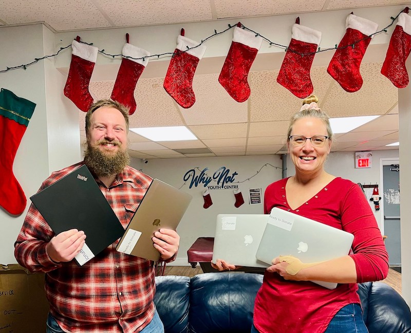 1Password staff handing over laptop at a Why Not Youth Centre in Canada.