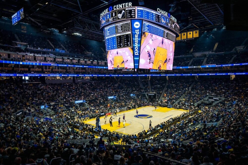 Basketball game at Chase Center with 1Password advertising visible on digital banners.